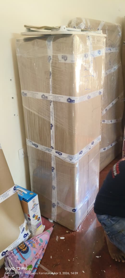 Professional household packing and shifting service in Bangalore by Harsha Packers & Movers using carton boxes and stretch wrapping